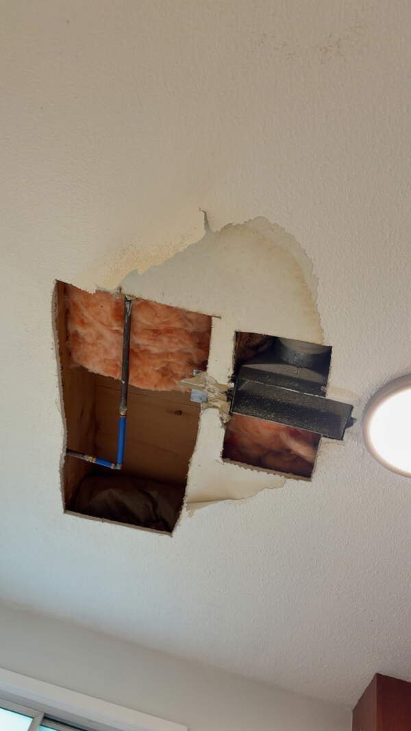 Opened wall showing a drywall repair area